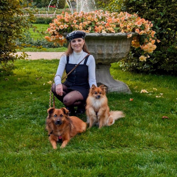 Frau mit zwei Hunden schaut in die Kamera.