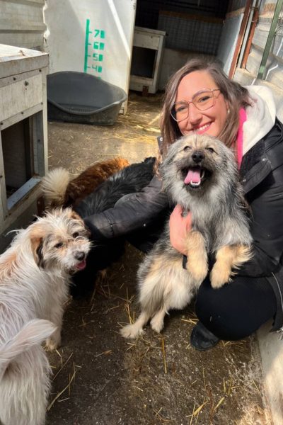 Frau mit Hunden schaut in die Kamera.