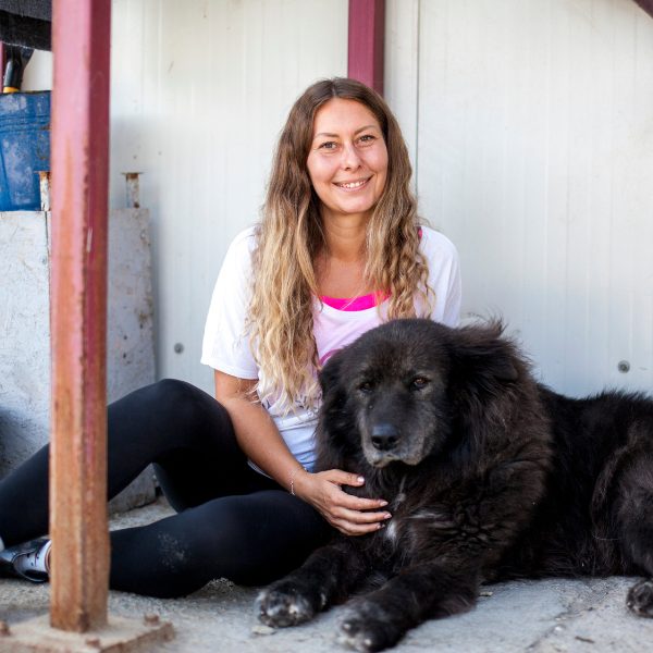 Frau mit Hund schaut in die Kamera