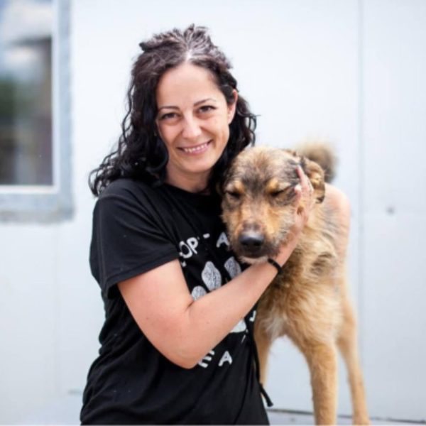 Frau mit Hund schaut in die Kamera