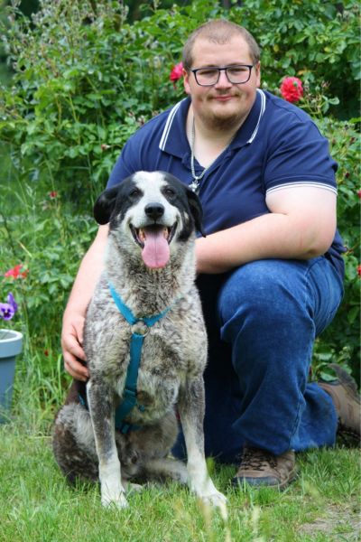 Ornilo sitzt neben einem Pfleger.