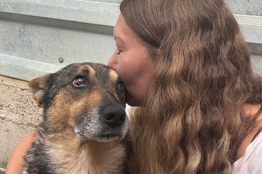 Eine Frau küsst einen Hund.