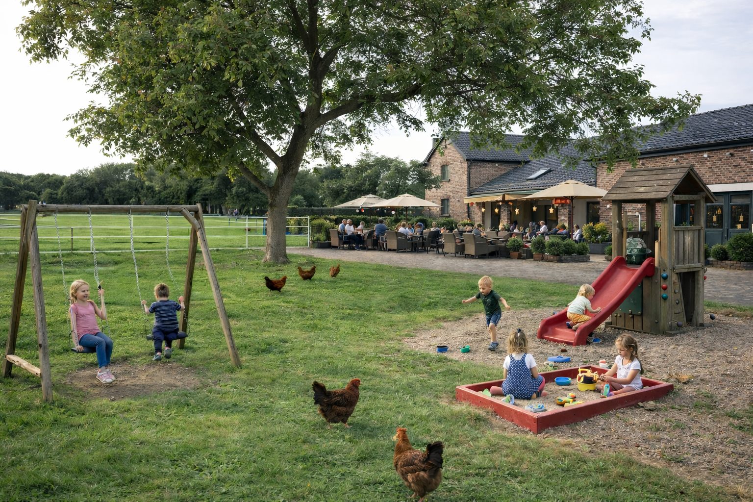 Spielplatz auf Wiese mit Hofcafé im Hintergrund