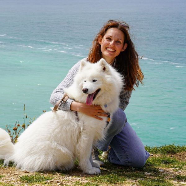Frau mit Hund schaut in Kamera