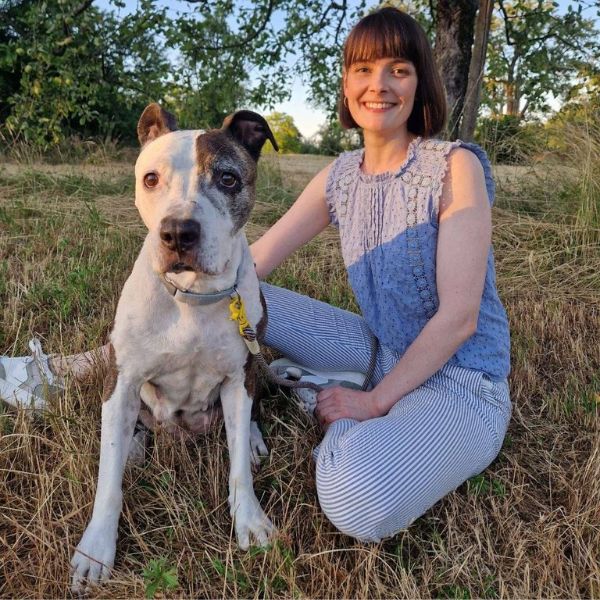 Frau mit Hund schaut in Kamera