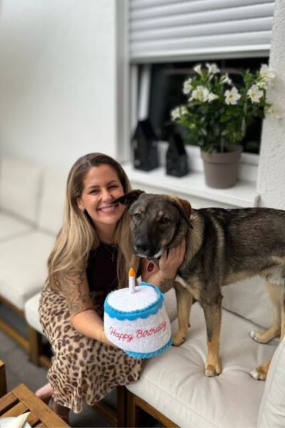 Ein Hund und sein Frauchen mit einer Geburtstagstorte.