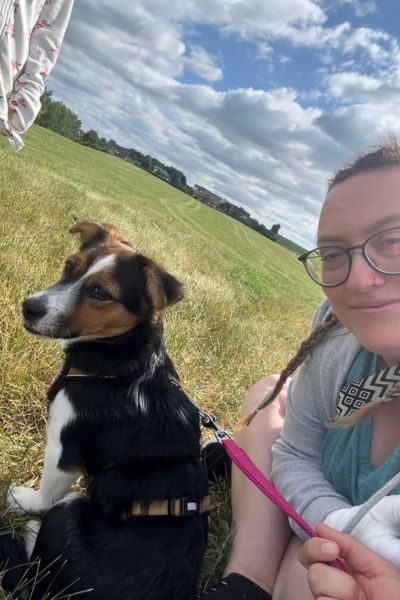 Eine Frau und ein Hund schauen in die Kamera.