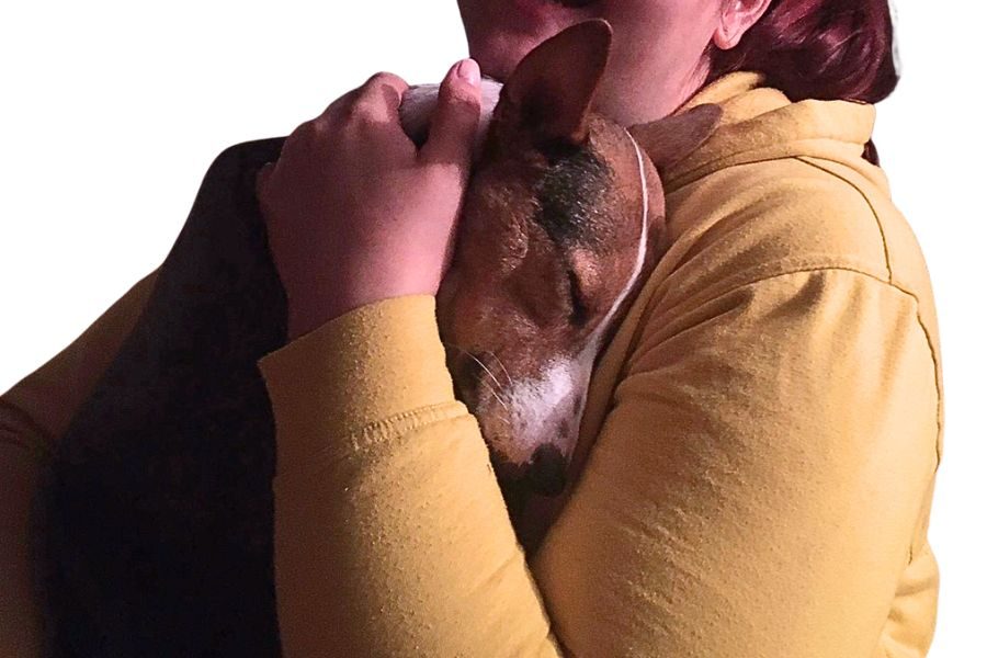 Ein Mensch und ein Hund umarmen sich.